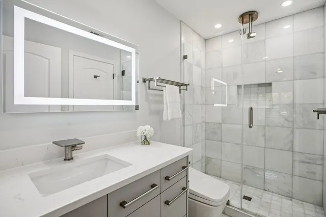 a bathroom with a sink a toilet and shower