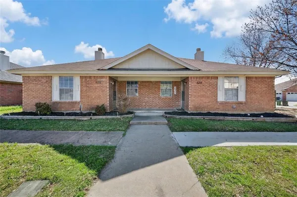 a front view of a house with a garden and yard