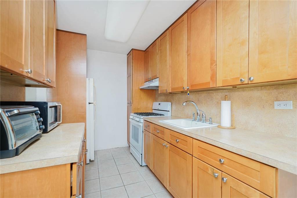 2630 Cropsey Avenue, Unit 9B Brooklyn, NY 11214 - Photo 15 of 29 a kitchen with a sink stove and cabinets