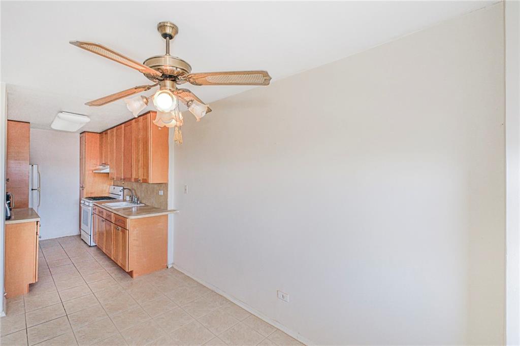 2630 Cropsey Avenue, Unit 9B Brooklyn, NY 11214 - Photo 9 of 29 a kitchen with a stove a refrigerator and ceiling fan