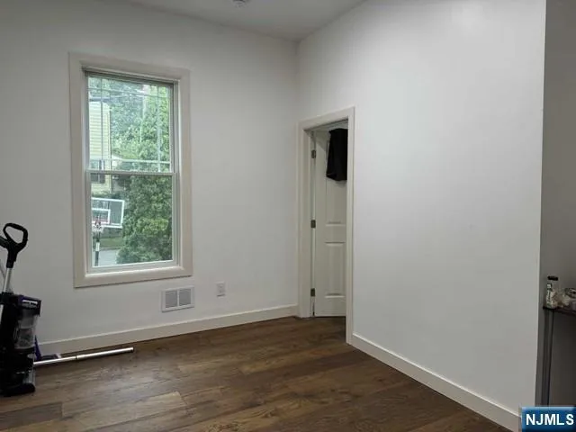 an empty room with wooden floor and closet