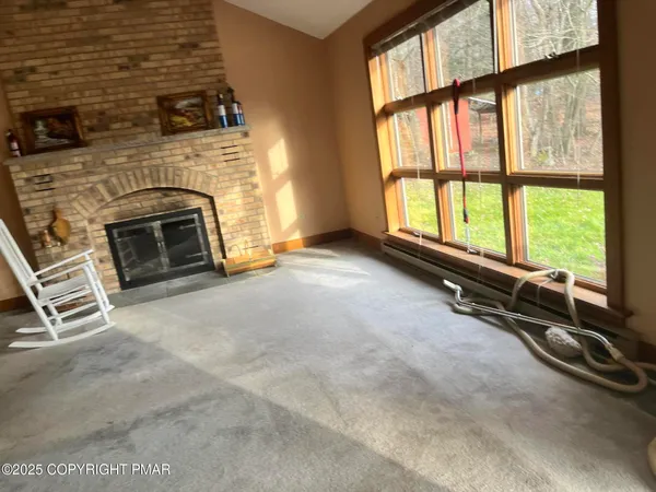 a living room with a fireplace and a floor to ceiling window