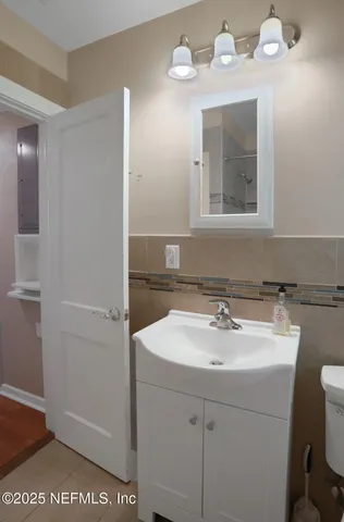 a bathroom with a sink a toilet and a mirror