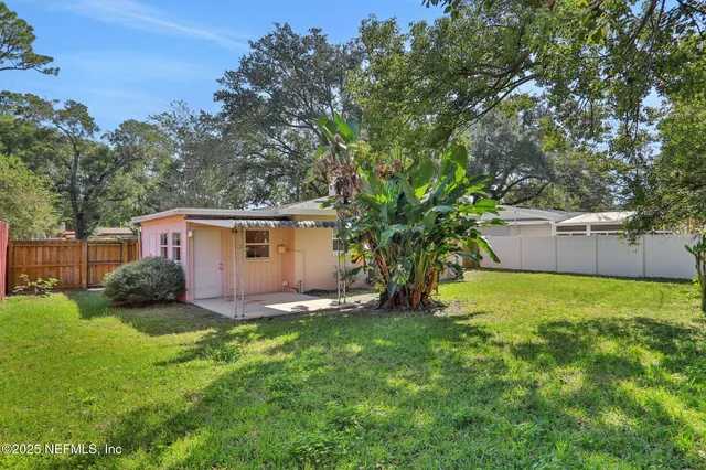 a view of backyard of house with green space