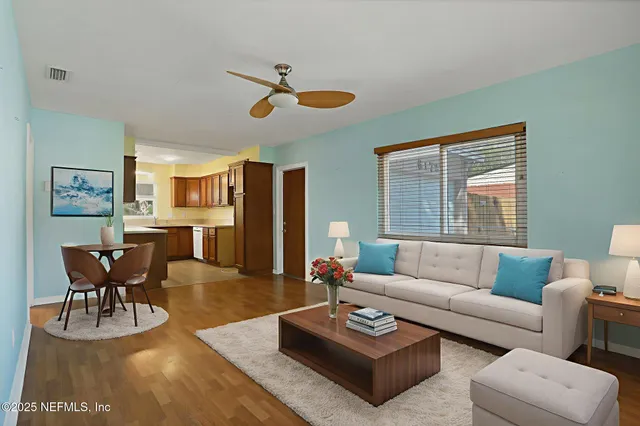 a living room with furniture wooden floor and a large window