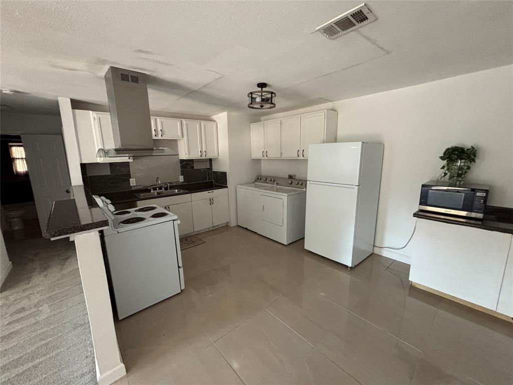 1303 East Myrtle Street, Unit A Fort Worth, TX 76104 - Photo 4 of 9 a kitchen with cabinets and white appliances