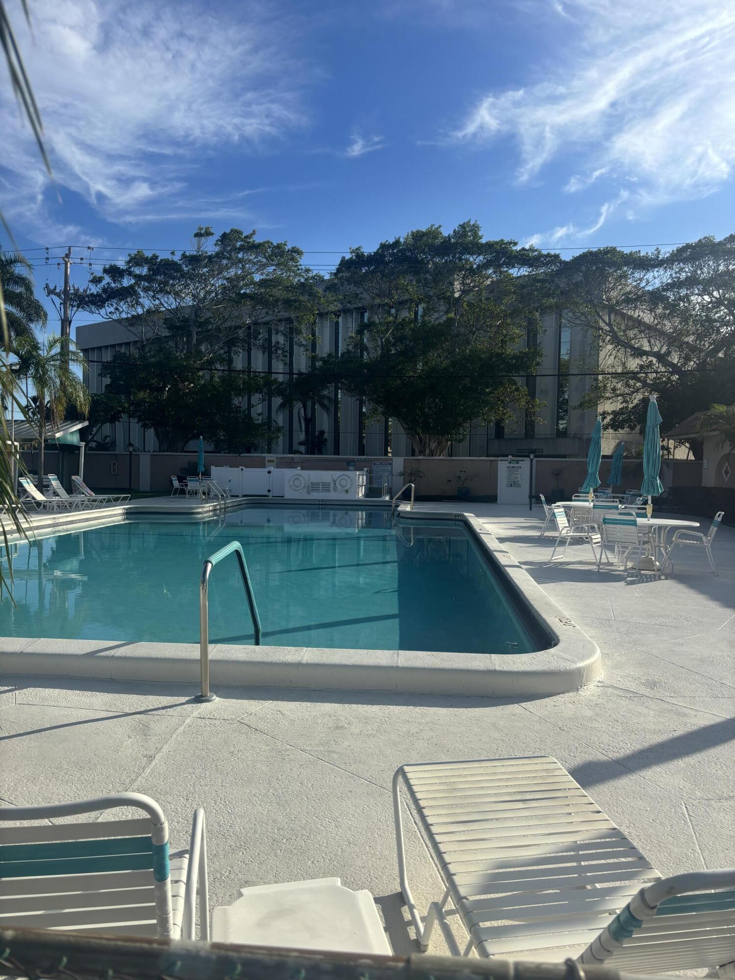 400 Northeast 20th Street, Unit A131 Boca Raton, FL 33431 - Photo 11 of 17 a view of a swimming pool with a table and chairs