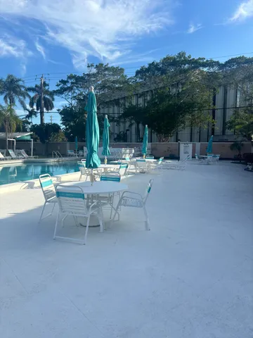 a view of a patio with a table and chairs under an umbrella