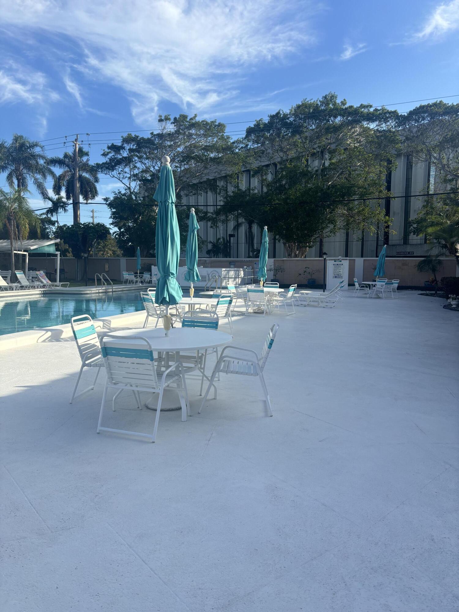 400 Northeast 20th Street, Unit A131 Boca Raton, FL 33431 - Photo 12 of 17 a view of a patio with a table and chairs under an umbrella