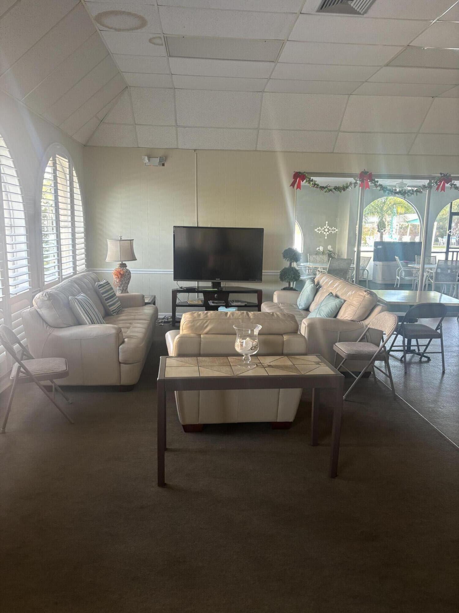 400 Northeast 20th Street, Unit A131 Boca Raton, FL 33431 - Photo 16 of 17 a living room with furniture and a flat screen tv