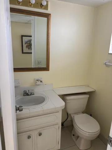 a bathroom with a toilet sink and mirror