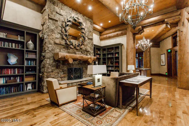 a living room with furniture a bookshelf and a chandelier