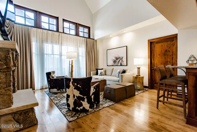 a living room with furniture and two large window