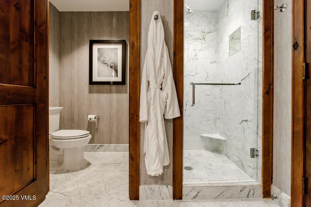 a bathroom with a granite countertop toilet and a shower