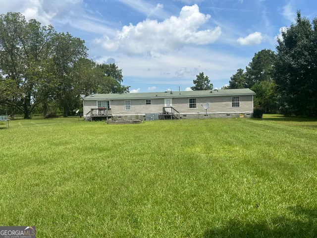 a view of a house with yard and a large tree
