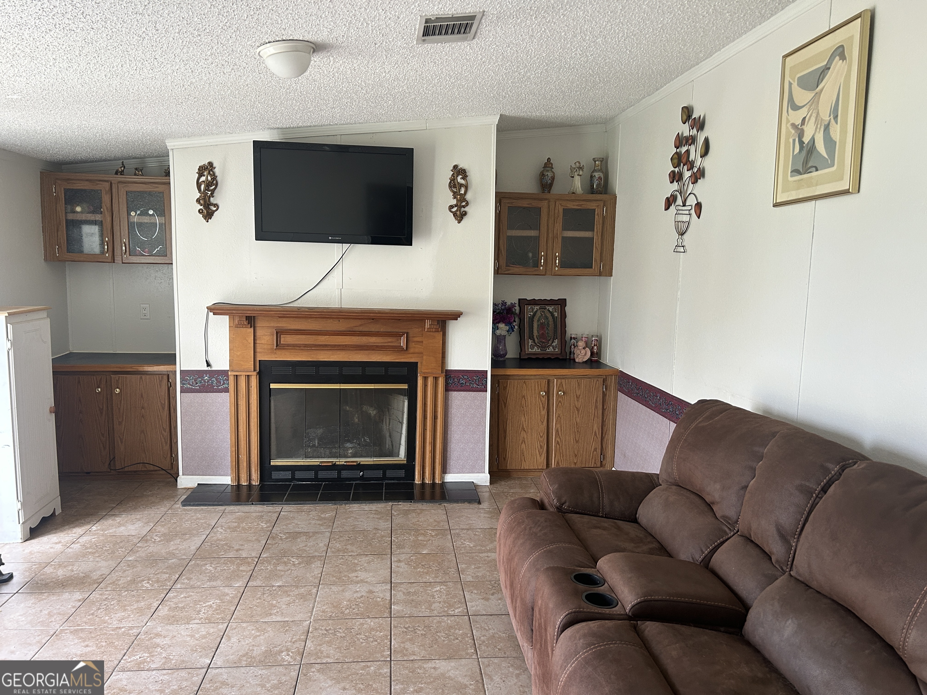 1105 River Road Fort Valley, GA 31030 - Photo 6 of 16 a living room with furniture a flat screen tv and a fireplace