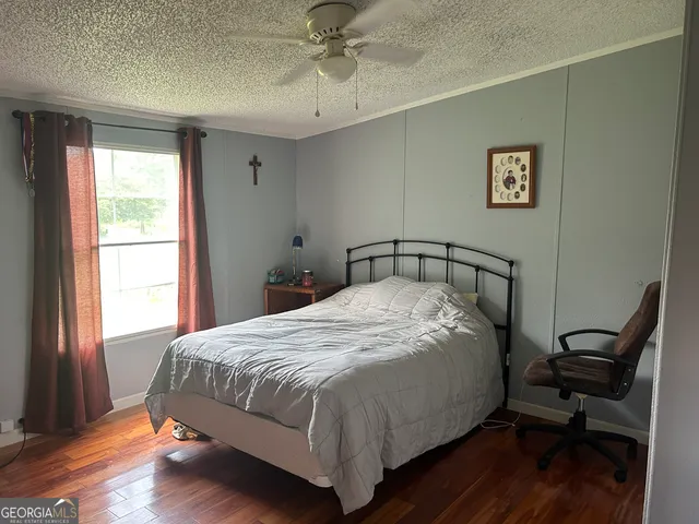 a bedroom with a bed and wooden floor