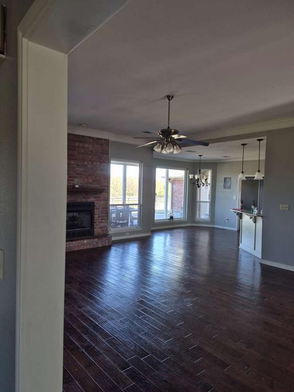 274 County Road Southwest Winnsboro, TX 75494 - Photo 22 of 26 an empty room with wooden floor chandelier and windows