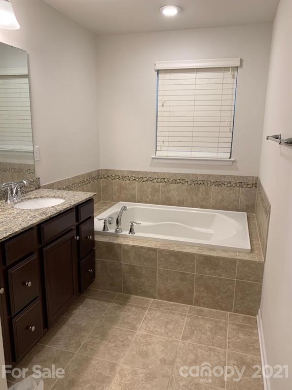 733 Dynamo Street Northwest Concord, NC 28027 - Photo 16 of 24 a bathroom with a granite countertop bathtub sink vanity and window