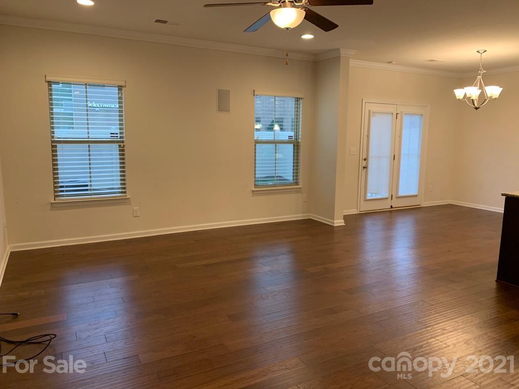 733 Dynamo Street Northwest Concord, NC 28027 - Photo 3 of 24 an empty room with wooden floor and windows