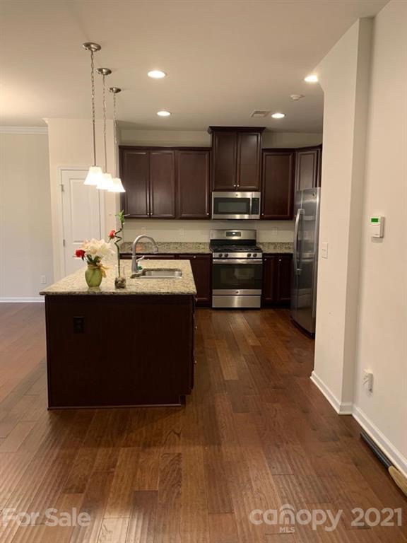 733 Dynamo Street Northwest Concord, NC 28027 - Photo 5 of 24 a kitchen with stainless steel appliances granite countertop a stove a sink and a refrigerator