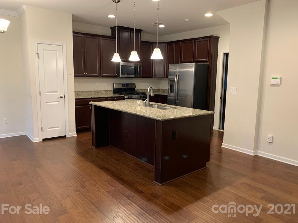 733 Dynamo Street Northwest Concord, NC 28027 - Photo 6 of 24 a kitchen with stainless steel appliances granite countertop a refrigerator a sink and a stove