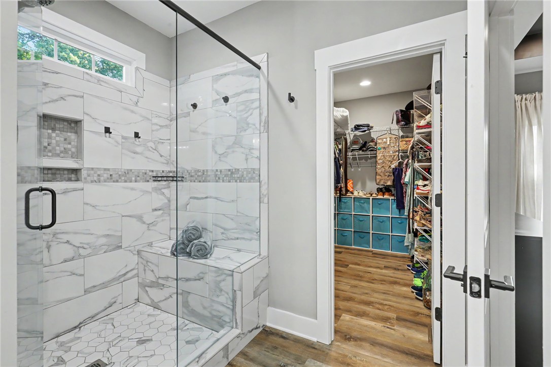 701 Coneross Creek Road Seneca, SC 29678 - Photo 16 of 35 The tiled walk-in shower sits just steps from a spacious walk-in closet, adding convenience to the primary suite.