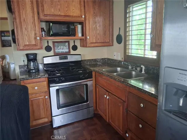 a kitchen with granite countertop a sink a stove and microwave