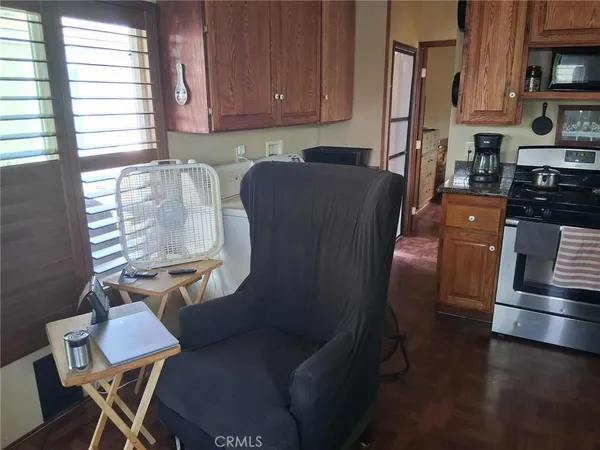 a kitchen with stainless steel appliances a refrigerator a stove a sink dishwasher and white cabinets with wooden floor