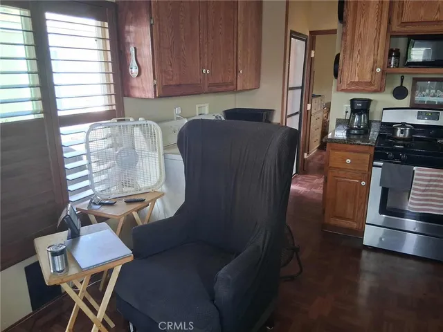 a kitchen with stainless steel appliances a refrigerator a stove a sink dishwasher and white cabinets with wooden floor