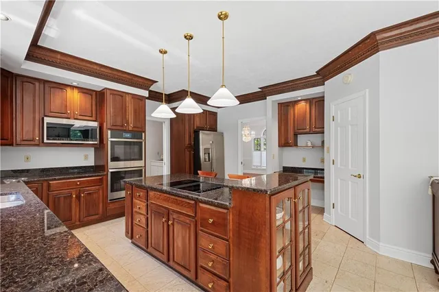 a kitchen with stainless steel appliances granite countertop a stove a sink and a refrigerator