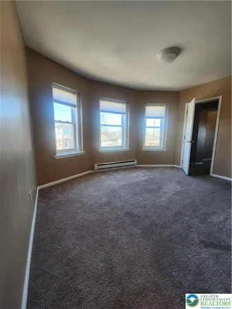 an empty room with windows and a fireplace