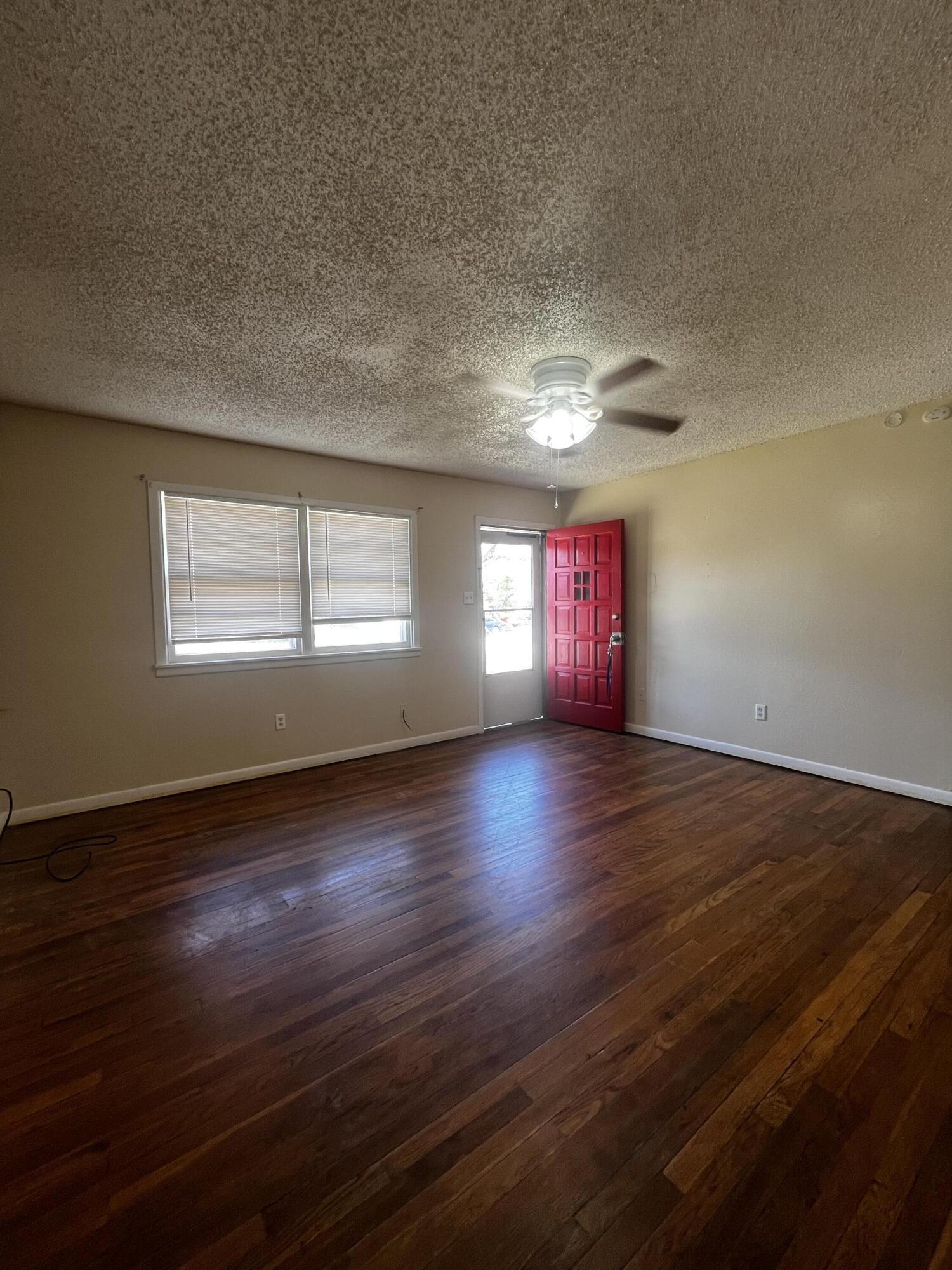 523 55th Street Lubbock, TX 79404 - Photo 2 of 7 an empty room with wooden floor and windows