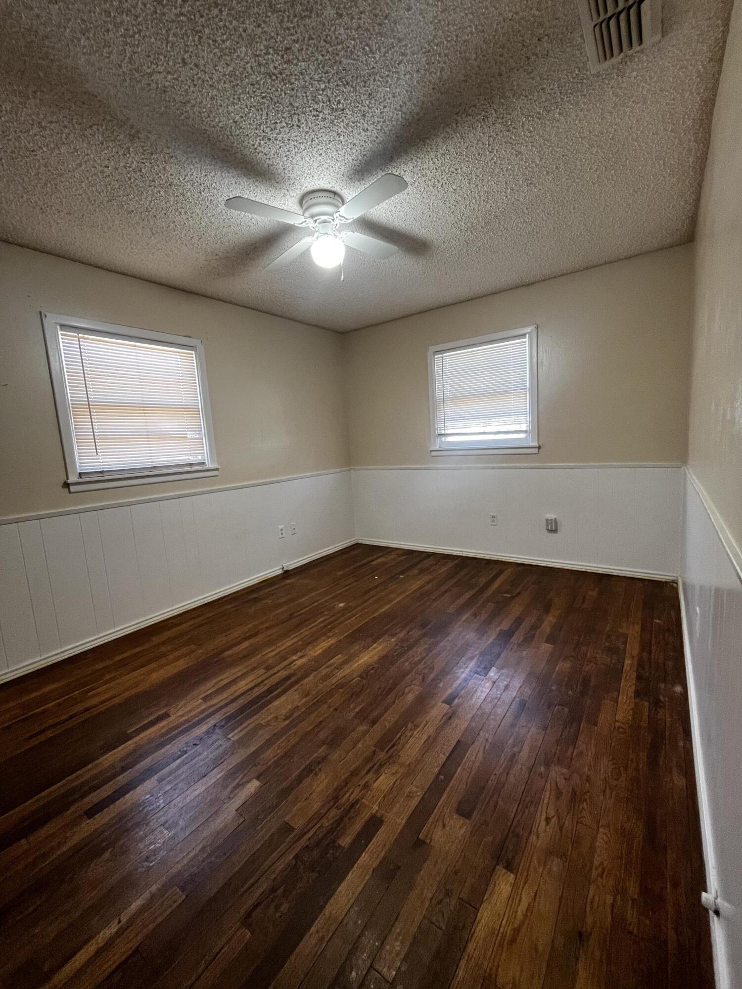 523 55th Street Lubbock, TX 79404 - Photo 6 of 7 an empty room with wooden floor and windows