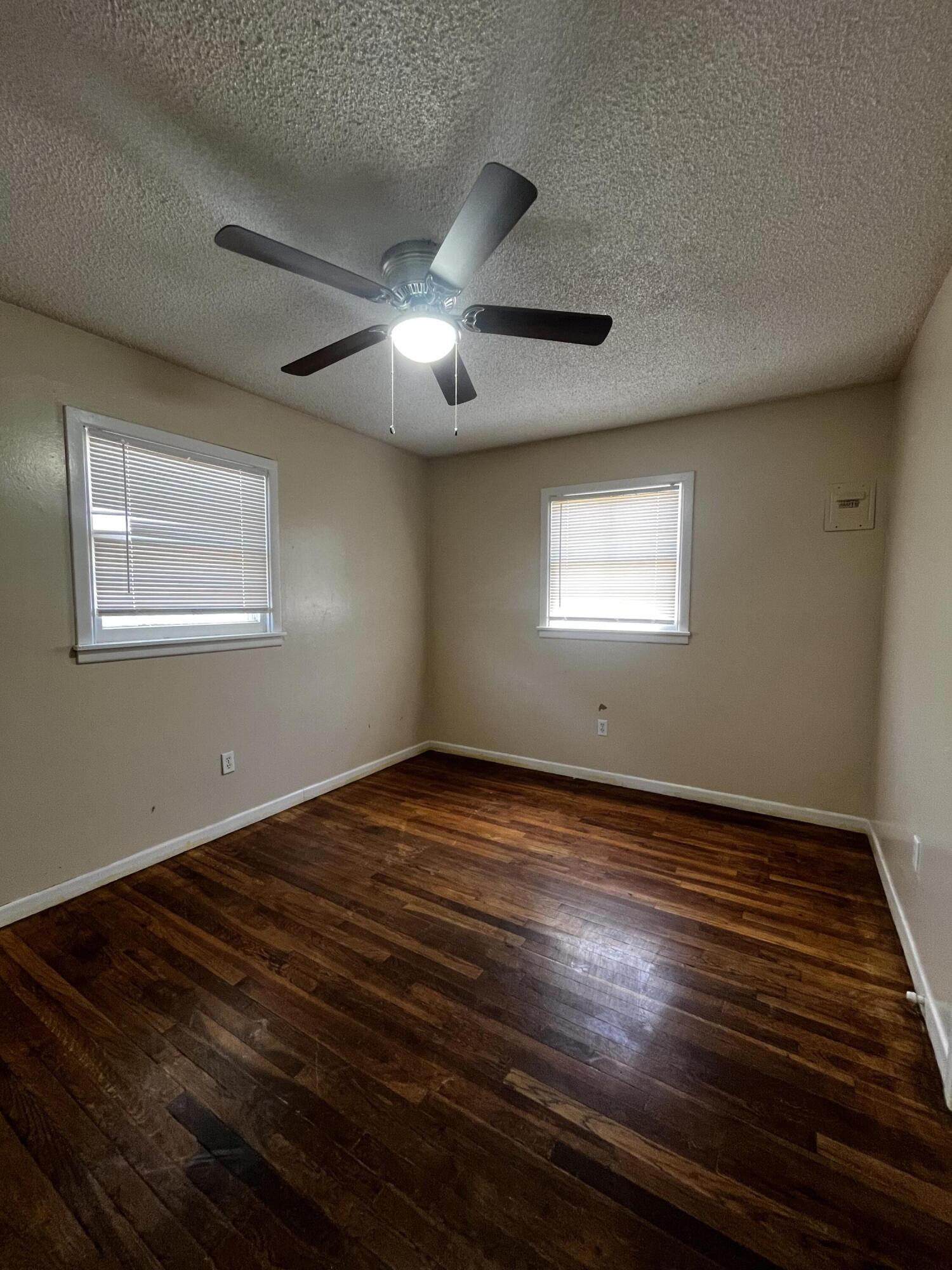 523 55th Street Lubbock, TX 79404 - Photo 7 of 7 a view of an empty room with wooden floor and a window