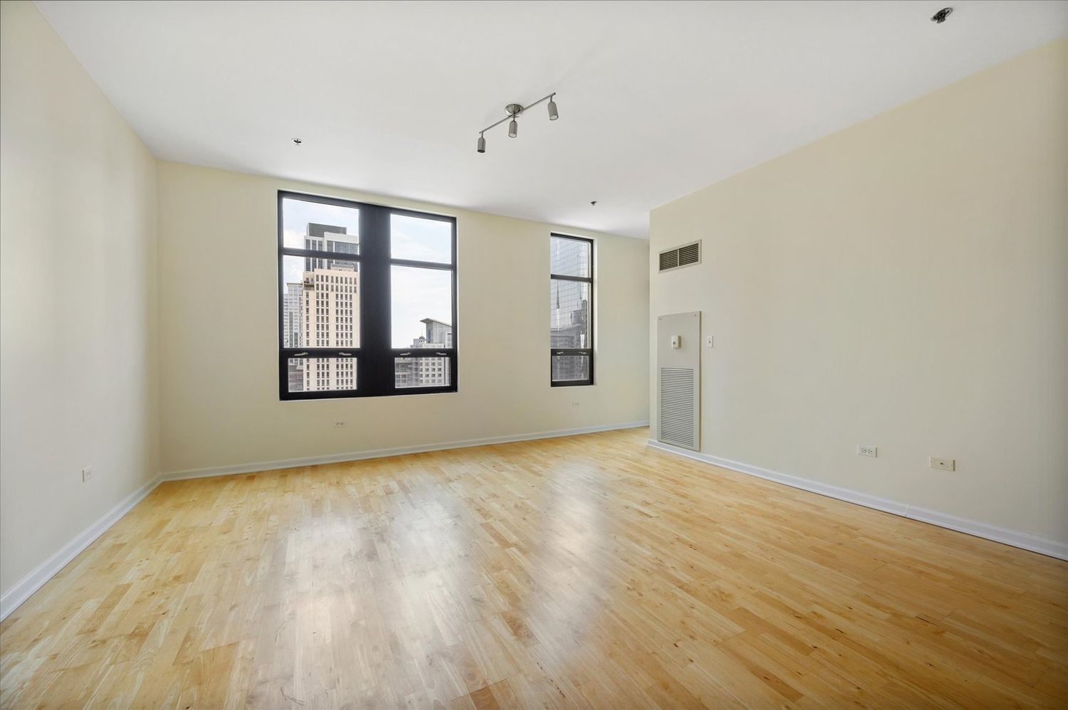 1255 South State Street, Unit 1913 Chicago, IL 60605 - Photo 12 of 21 a view of an empty room with wooden floor and a window