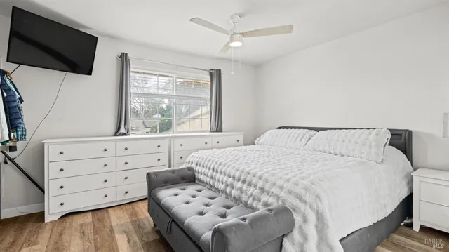 a bedroom with a large bed and a flat tv screen on dresser