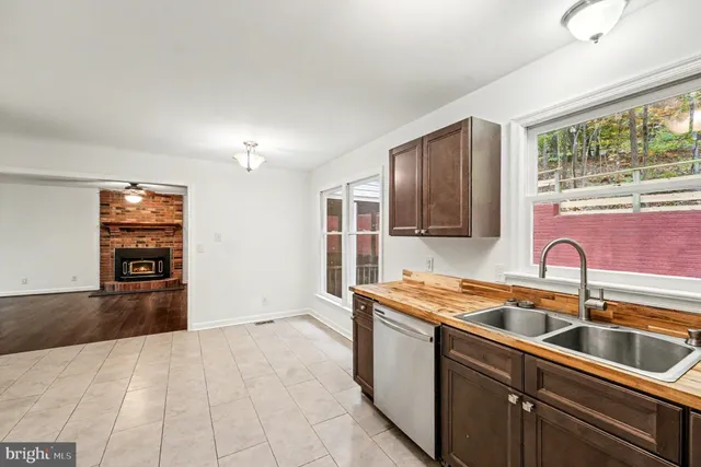 a large kitchen with stainless steel appliances kitchen island granite countertop a refrigerator and a sink
