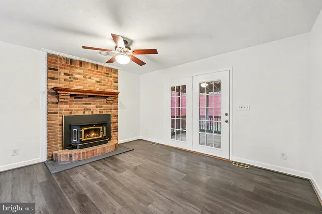 a view of a livingroom with a fireplace and chandelier fan