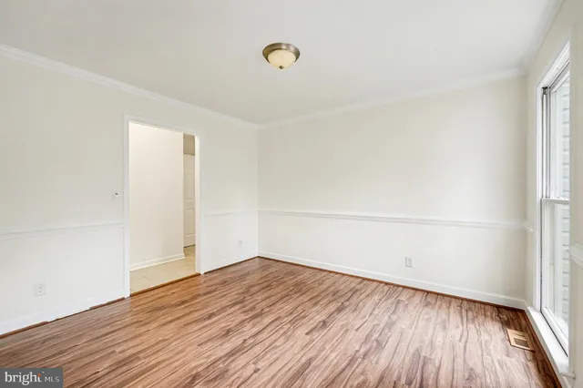 a view of a room with wooden floor and white walls