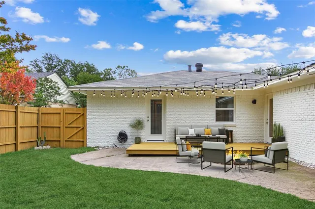 a view of a house with backyard and sitting area