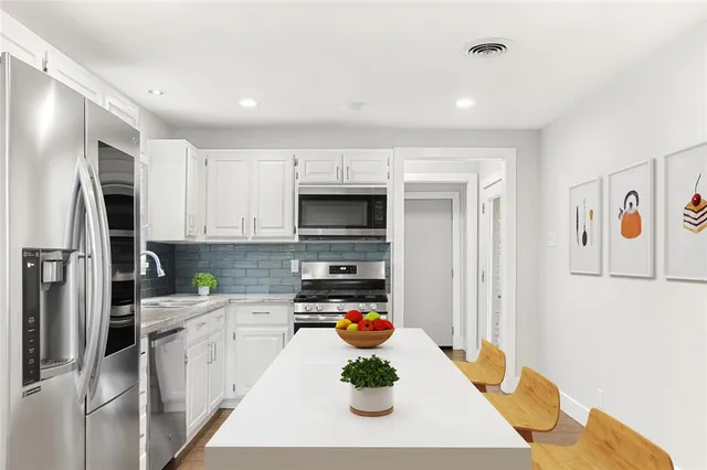 a kitchen with stainless steel appliances granite countertop a refrigerator and a sink