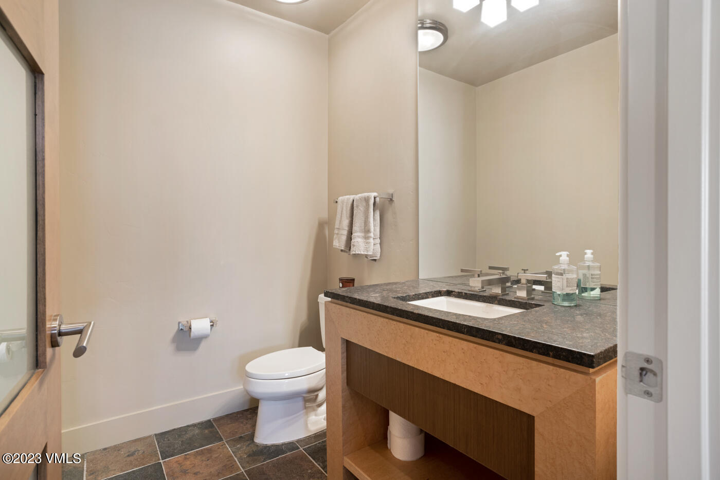 83 Eagle River Road Edwards, CO 81632 - Photo 35 of 64 a bathroom with a granite countertop sink a toilet and a mirror