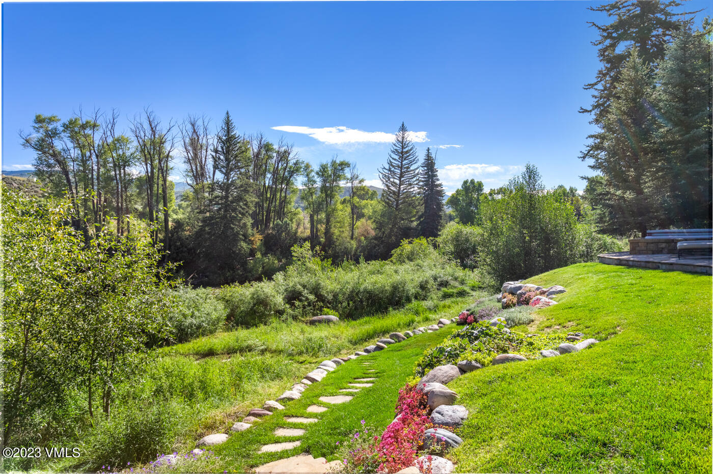 83 Eagle River Road Edwards, CO 81632 - Photo 57 of 64 a view of a garden with a building in the background