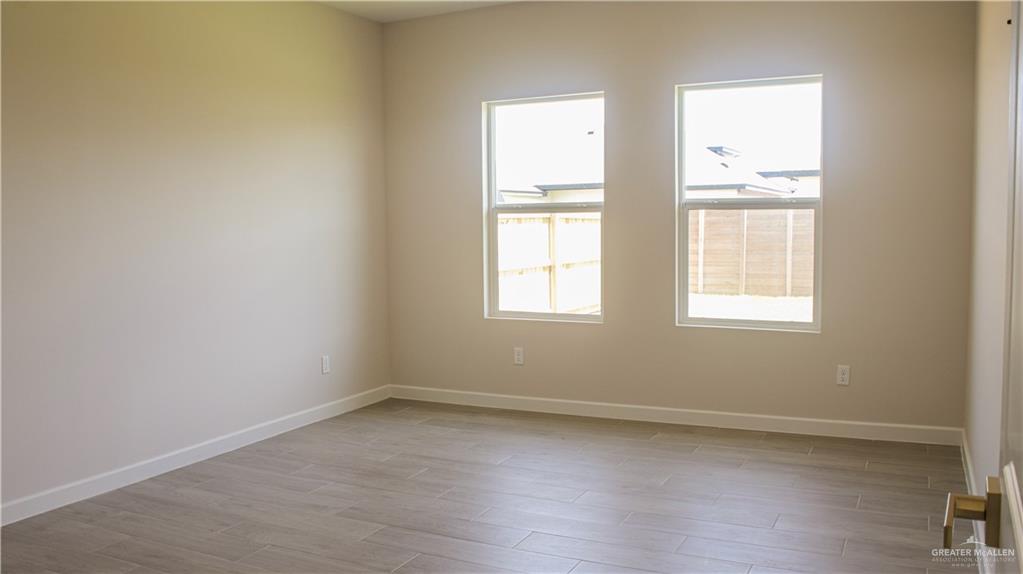 900 Azalea Street Mission, TX 78573 - Photo 12 of 12 Interior room with two white-framed windows, light neutral wall paint, and wood-finish tile flooring