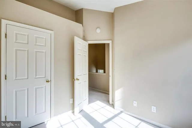 a view of a hallway with wooden floor and a bathroom