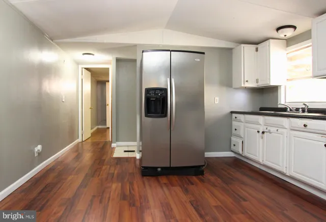 a view of a kitchen with wooden floor and electronic appliances