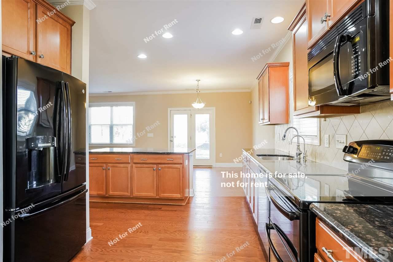 7549 Channery Way Raleigh, NC 27616 - Photo 13 of 27 a large kitchen with stainless steel appliances granite countertop a stove a sink and a refrigerator