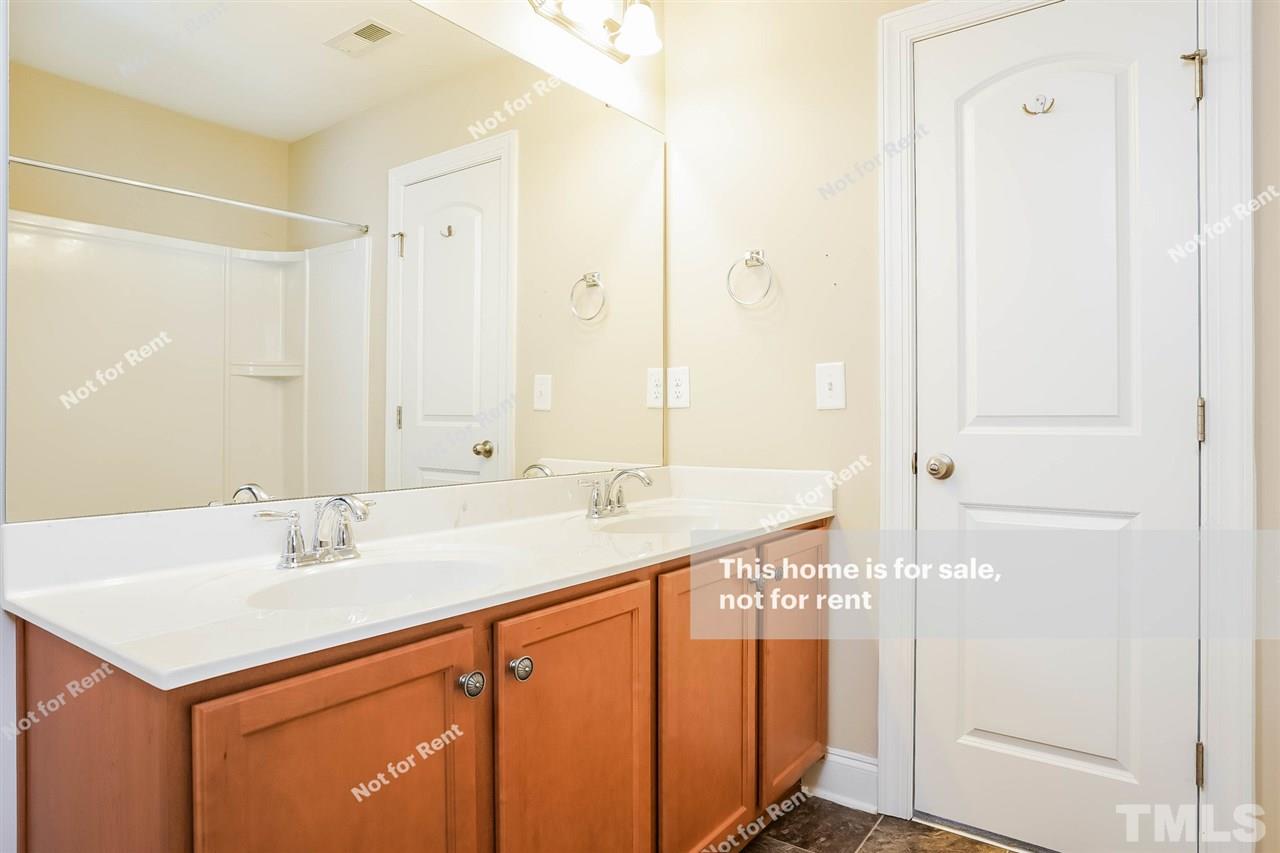 7549 Channery Way Raleigh, NC 27616 - Photo 25 of 27 a bathroom with a sink and a mirror