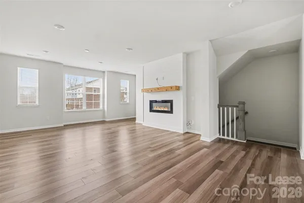 a view of kitchen center island wooden floor and stainless steel appliances